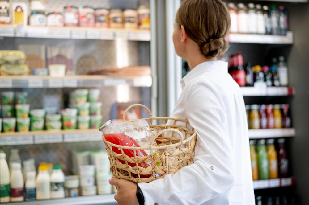 Klientka robiąca zakupy w sklepie spożywczym z produktami chłodzonymi