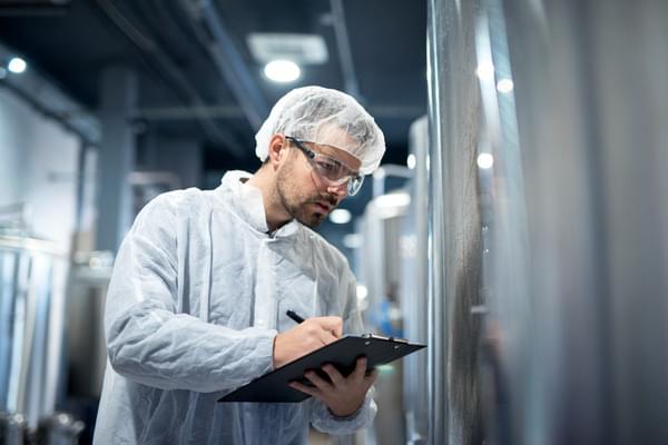 Inspektor DDD sprawdzający wymogi sanitarne w zakładzie produkcyjnym żywności 