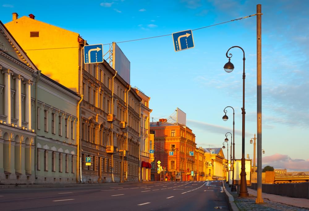 Reprezentacyjna szeroka ulica w blasku zachodzącego słońca otoczona klasycznymi budynkami oraz urzędami. To właśnie w tego typu placówkach publicznych niezbędne jest utrzymanie najwyższych standardów higieny i przeprowadzanie regularnych zabiegów sanitarnych.
